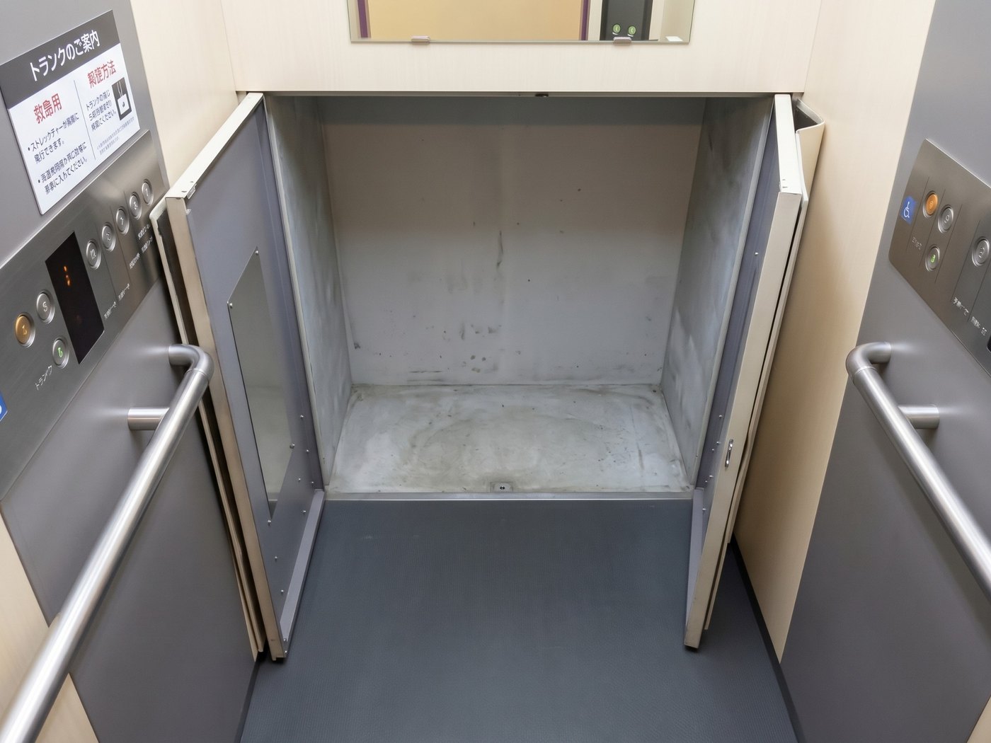 奥の壁が開いて、荷物を入れるトランクスペースが現れたエレベーター内部の写真
